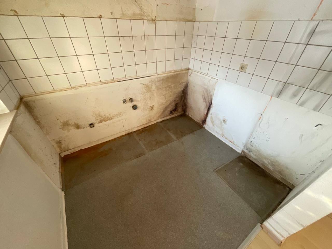 Schimmelbefall in der Küche hinter entfernten Fliesen